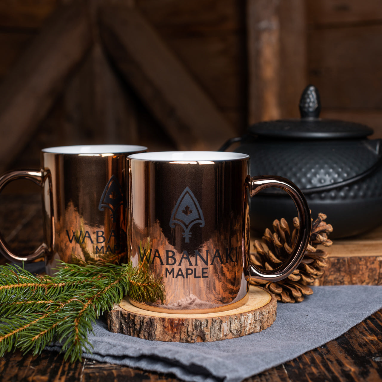 Wabanaki Maple Coffee Mug pictured with a black kettle in the background